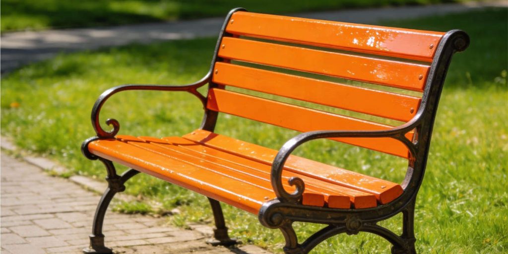 Zu sehen ist eine orange angemalte Bank. 